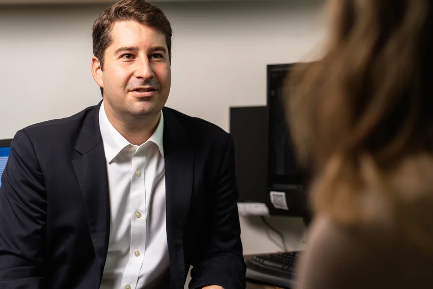 Office worker experiencing lower back pain while leaning over desk